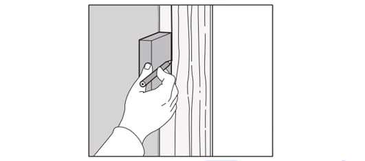 Someone draws a line to know where to cut the filler piece so it’s the same height as the cabinet.