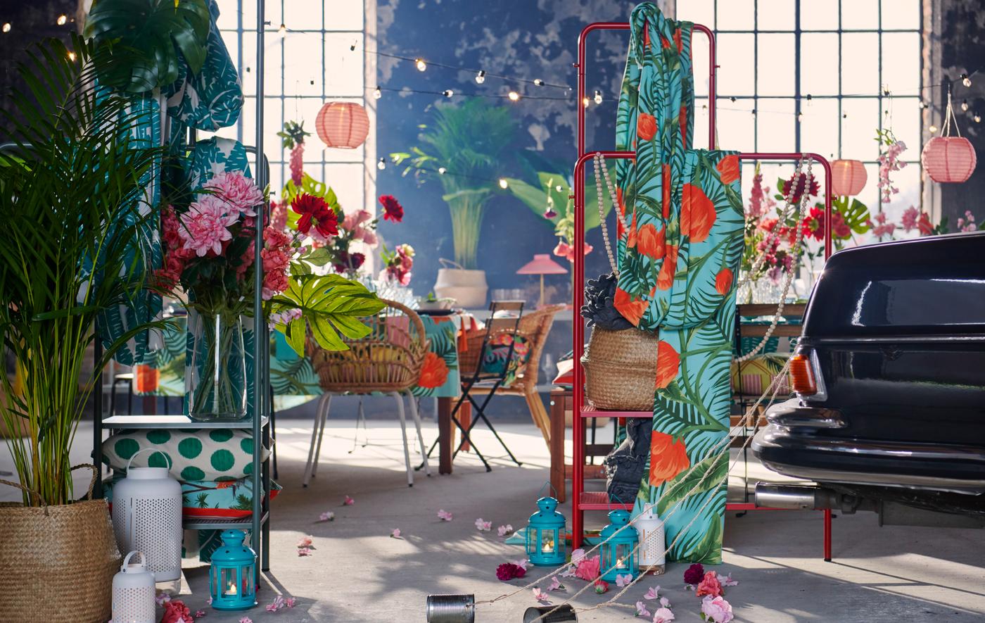 Spacious, industrial interior set for a party with textiles, decorations, plants and the end of a car with trailing tin cans.