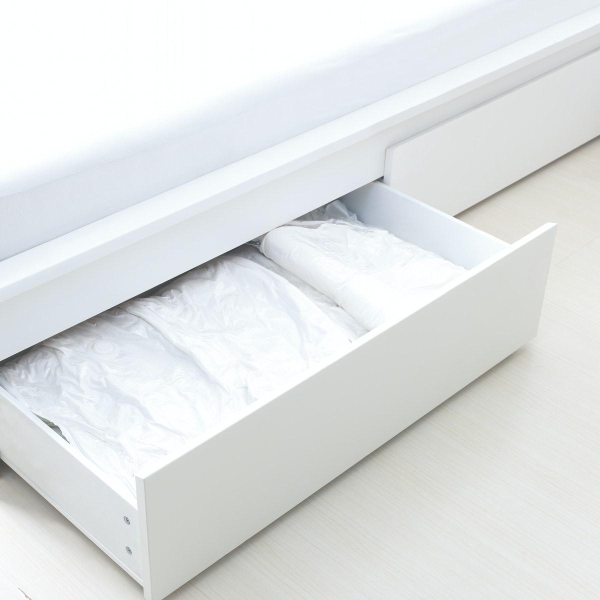 SPANTAD Vacuum-sealed bag stored in a drawer under a bed. 