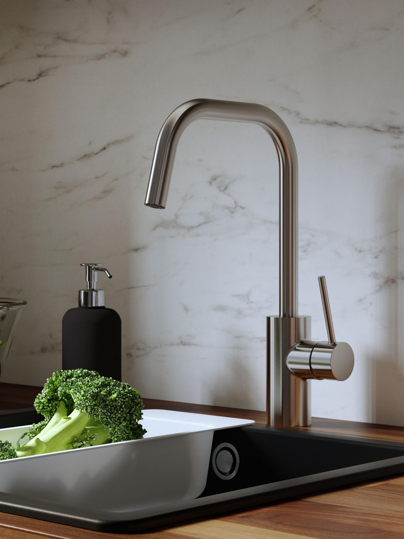 Stainless steel VIMMERN kitchen mixer tap with handspray on a round BOHOLMEN inset sink, a colander on the wall behind.