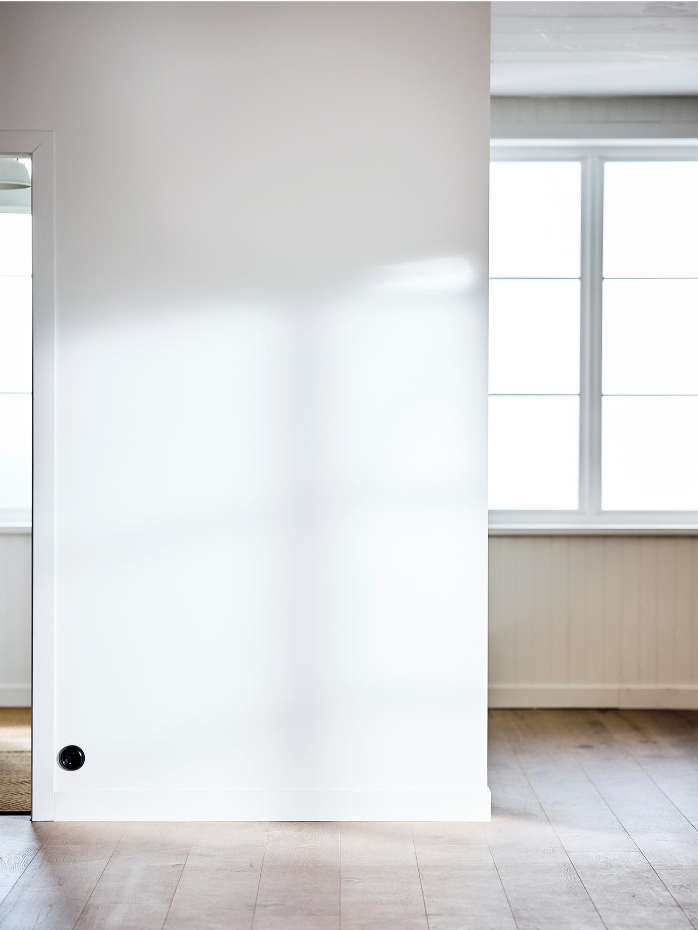 Stanza vuota con un'ampia finestra, pareti dipinte di bianco e parquet con mordente bianco - IKEA