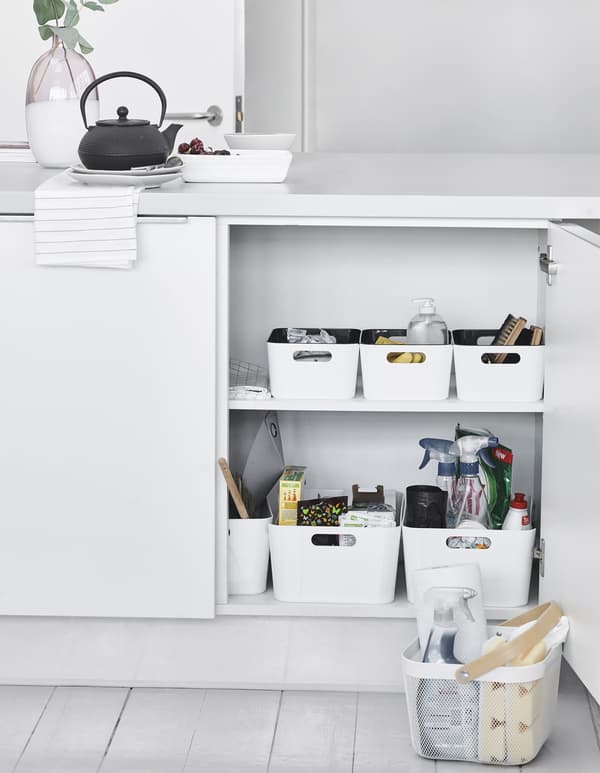 Storage boxes inside a kitchen cupboard.