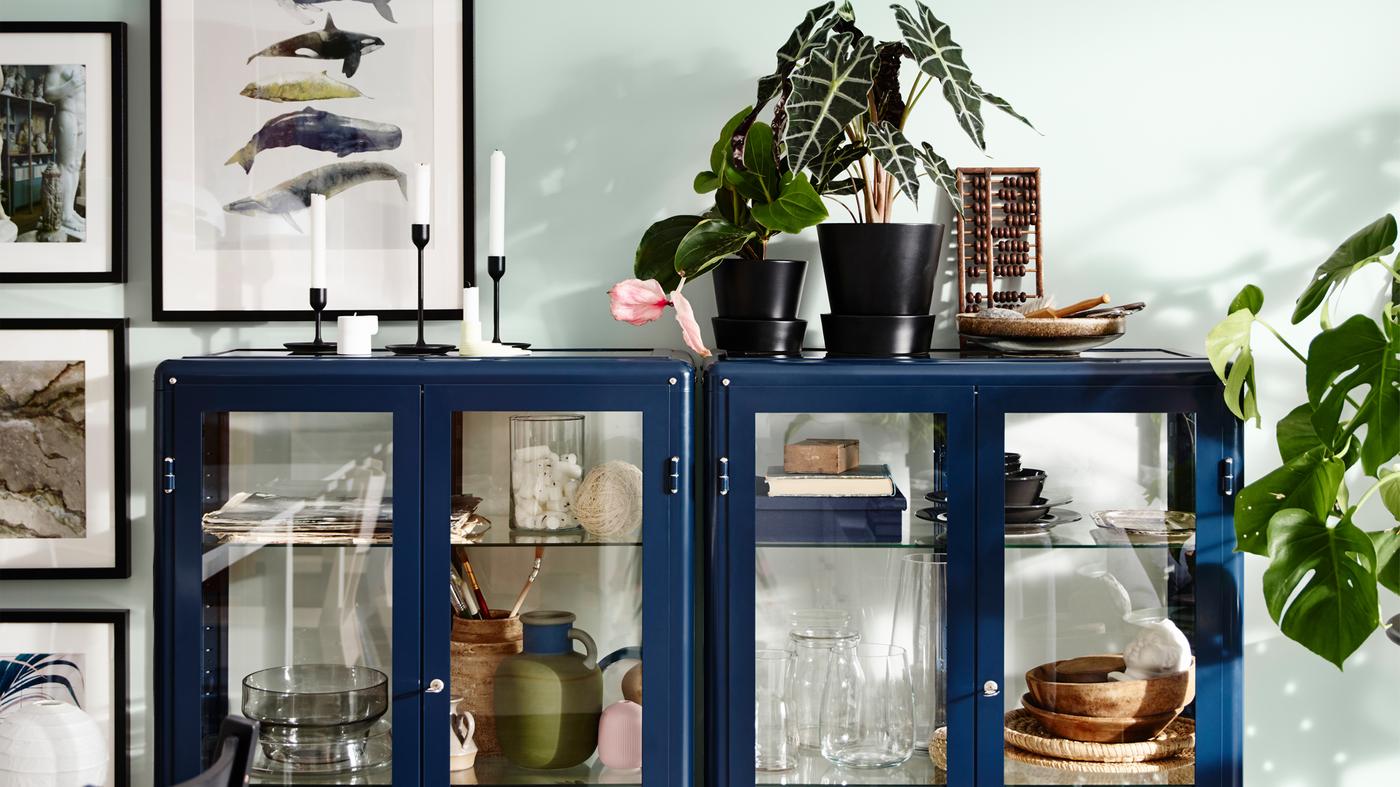 Storage in a living room with FABRIKÖR glass-door cabinets in blue.