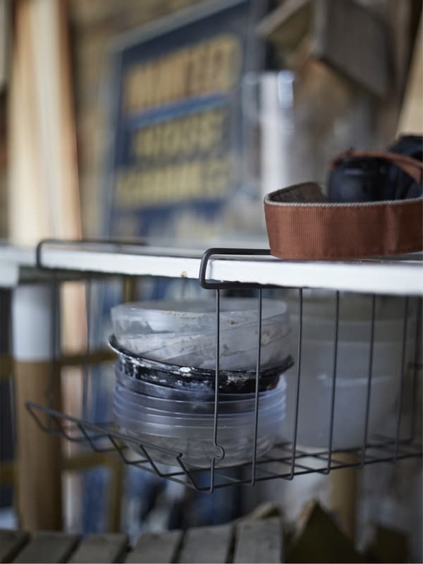Storage trays hanging under a shelf