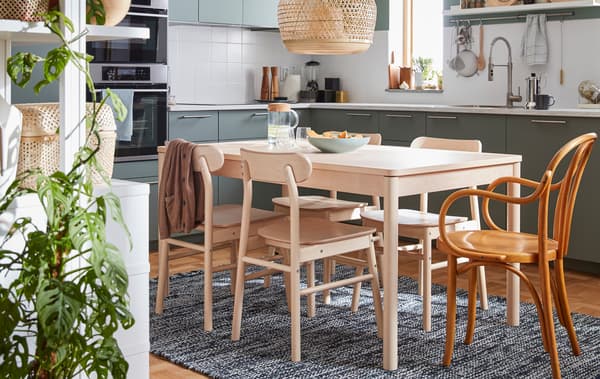 Table à dîner en bouleau et quatre chaises de la collection RÖNNINGE ainsi qu’une chaise IKEA des années 60.