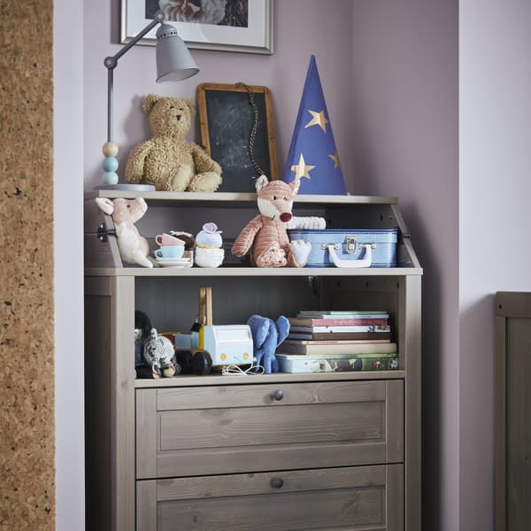 Table à langer/commode avec des jouets et des livres.