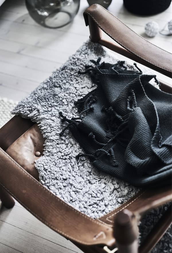 Tapis gris posé sur une chaise.