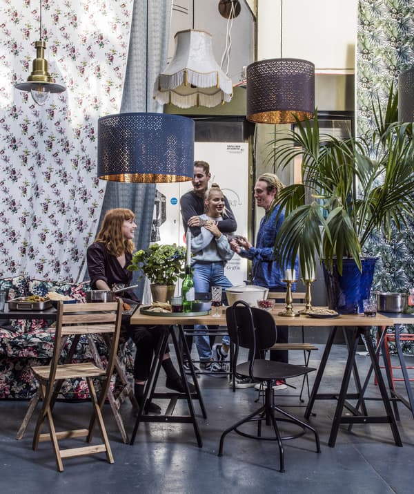 Tavoli e sedie con persone che socializzano e lampade pensili - IKEA