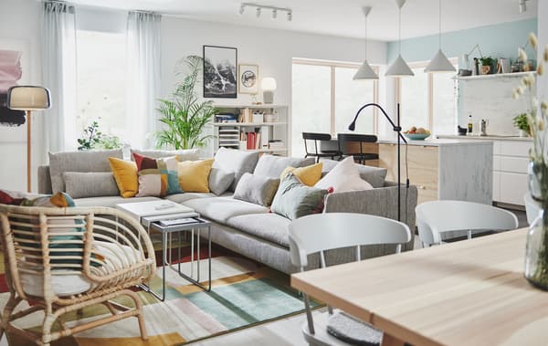 Teil eines grossen Raumes mit Küchenbereich und Kücheninsel, daneben ein Wohnbereich mit einem grossen Ecksofa.