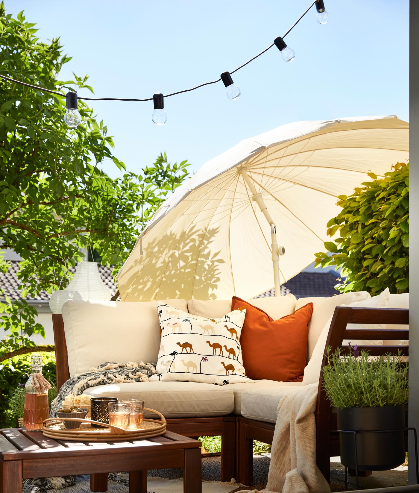 Terrasse ensoleillée avec salon de jardin en bois et parasol