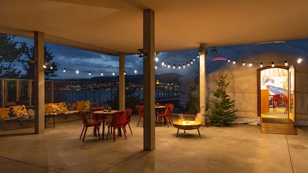 Terrasse neben einer Jurte mit Tischen und Stühlen und Beleuchtung mit Lichterketten