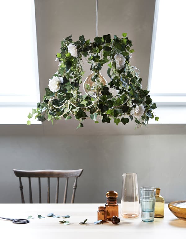 Testez une façon différente d'importer un bout de nature à l'intérieur en relookant une vieille lampe au moyen de fleurs artificielles et de plantes vertes. IKEA propose un large choix des unes et des autres!