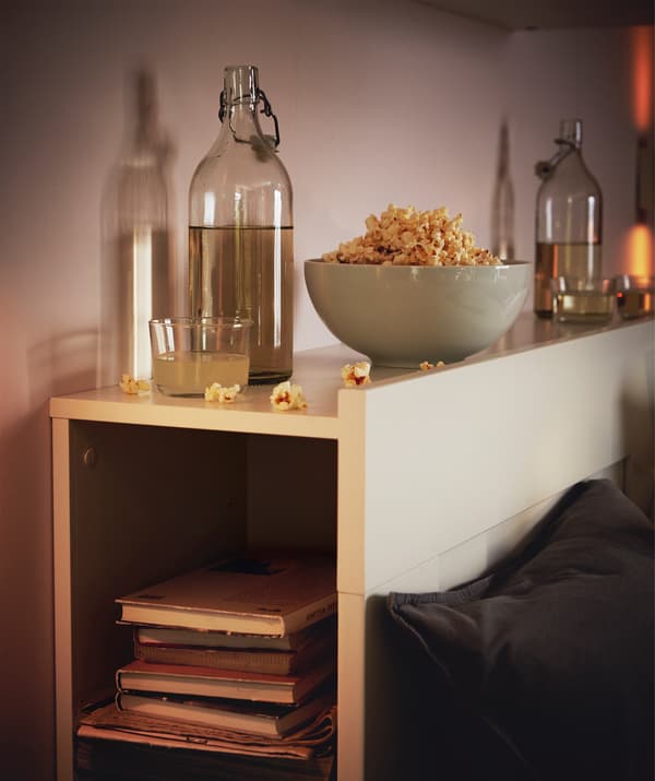 Testiera di un letto che funge da libreria e ripiano per bottiglie e snack - IKEA