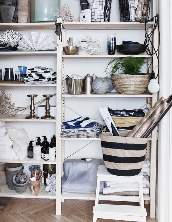 Textiles, plantes et objets décoratifs sur une étagère.