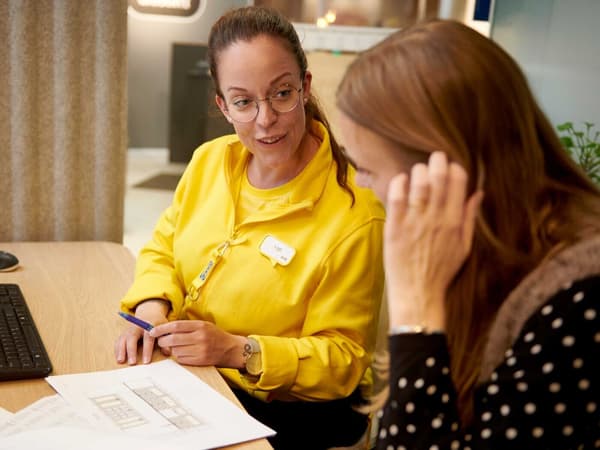The customer and the IKEA co-worker discuss the plan at the table.