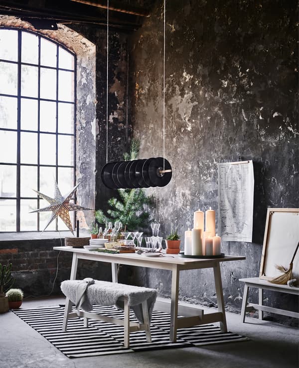 The dining area of an industrial loft apartment with a bench and table ready for buffet serving.