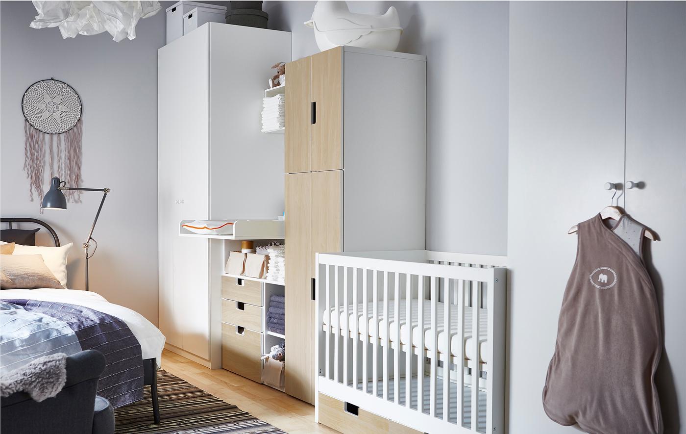 This nursery idea places a cot, changing table and babies storage in between two wardrobes for the parents.