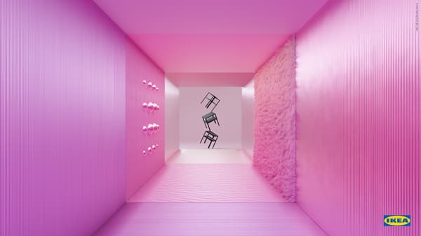 Three, black KNARREVIK bedside tables balance one above the other, at the end of a pink corridor with textured walls.