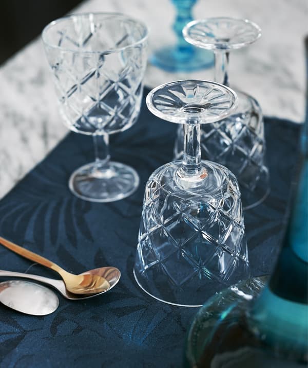 Three cut-glass wine glasses on the dining table.