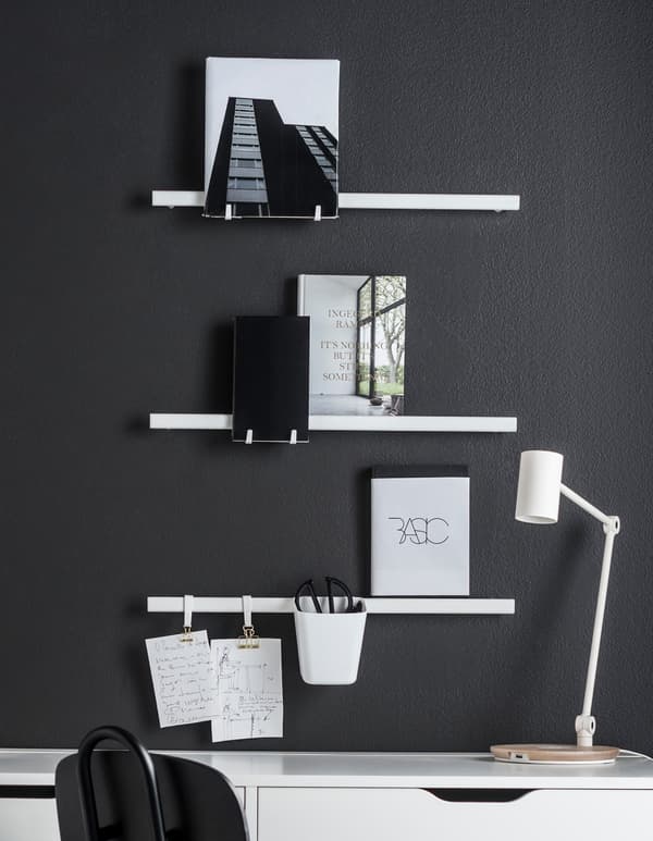 Three SUNNERSTA white rails mounted to a wall by a desk, holding notes and a white cup holder for scissors and supplies.