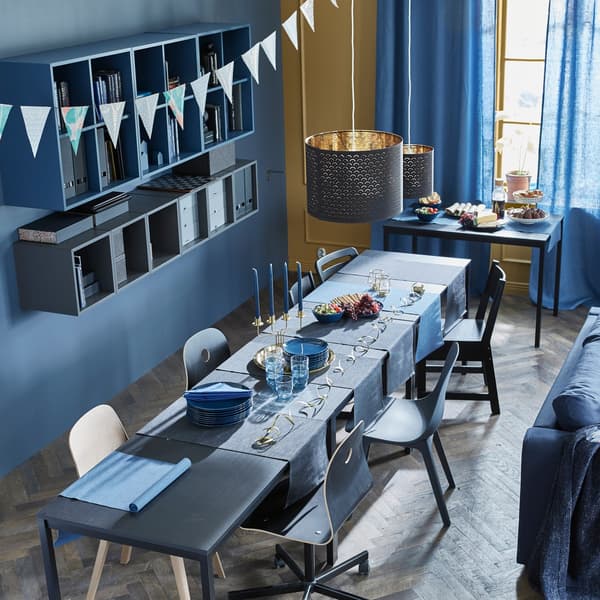 Three tables are arranged lengthwise for a dinner party, while a fourth table serves as a buffet table.