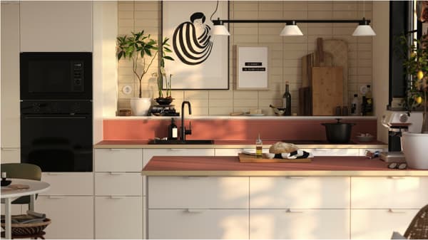 Tijdloze keuken met witte kasten, een METOD keukeneiland met terracotta werkblad, zwarte spoelbak en elegante decoratie
