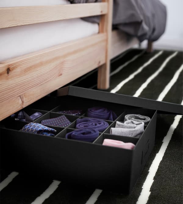 TJENA box with compartments under a bed, with socks and small accessories.