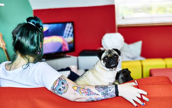 Toni and her dog sitting on a red sofa.