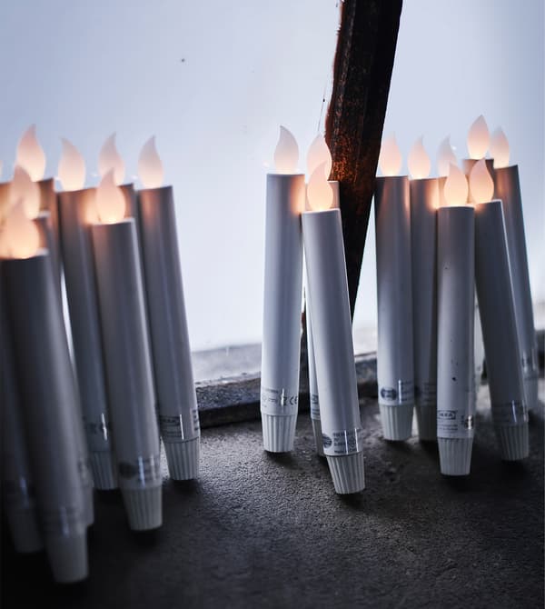 Toute une série de bougies à LED sont appuyées contre la fenêtre.