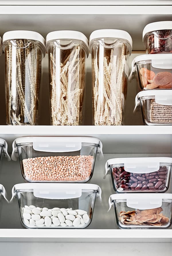 Transparent storage containers make it easy to see the grains and other dry goods in this kitchen cabinet.