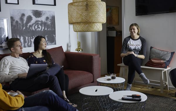 Trois personnes prenant le café dans un séjour.