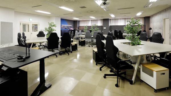 ５つのテーブルと、それぞれを囲うようにオフィスチェアとデスク収納が並ぶプログラミングラボの様子