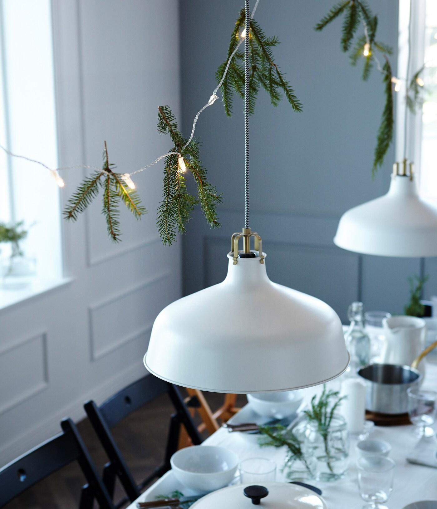Tu veux une table de fêtes épatante ? La décoration au-dessus de la table apporte une touche de convivialité et d'intimité. Nous avons utilisé une guirlande lumineuse et des branches de sapin.