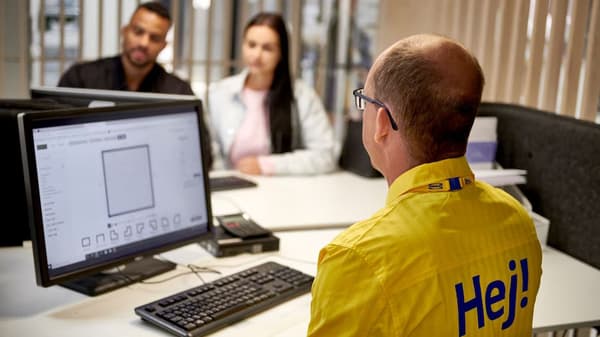 Två kunder som planerar sitt kök med hjälp av en IKEA medarbetare