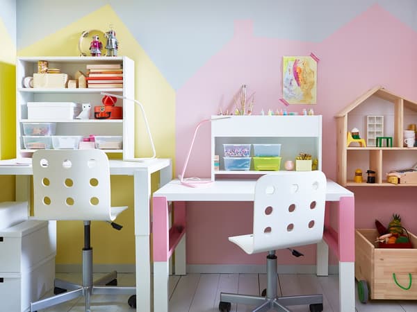 Two adjustable desks and chairs side-by-side in a shared kids’ room.