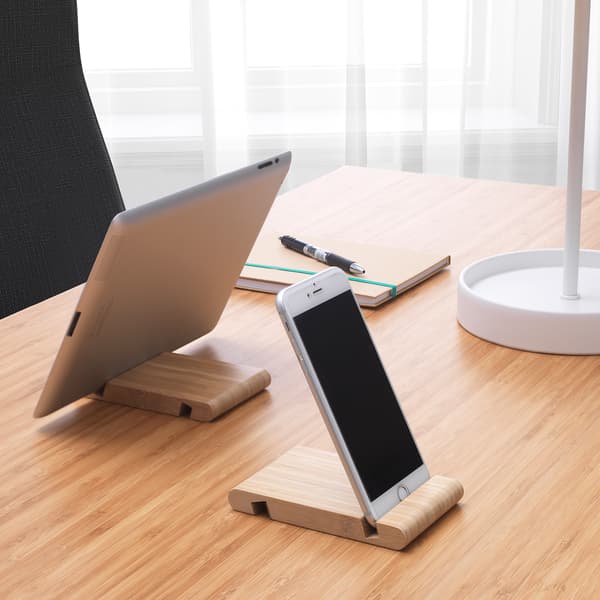Two BERGENES stands on a bamboo tabletop, one holding a mobile phone and the other, a tablet.