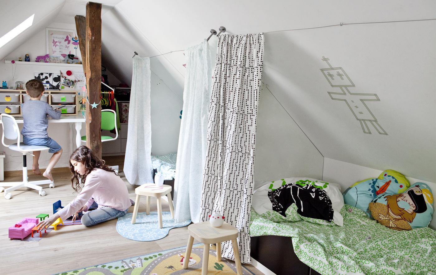 Two children playing in a shared bedroom.