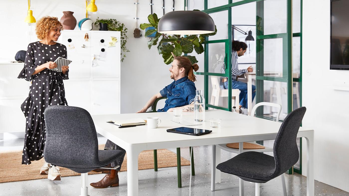 Two co-workers are discussing about work at the office.