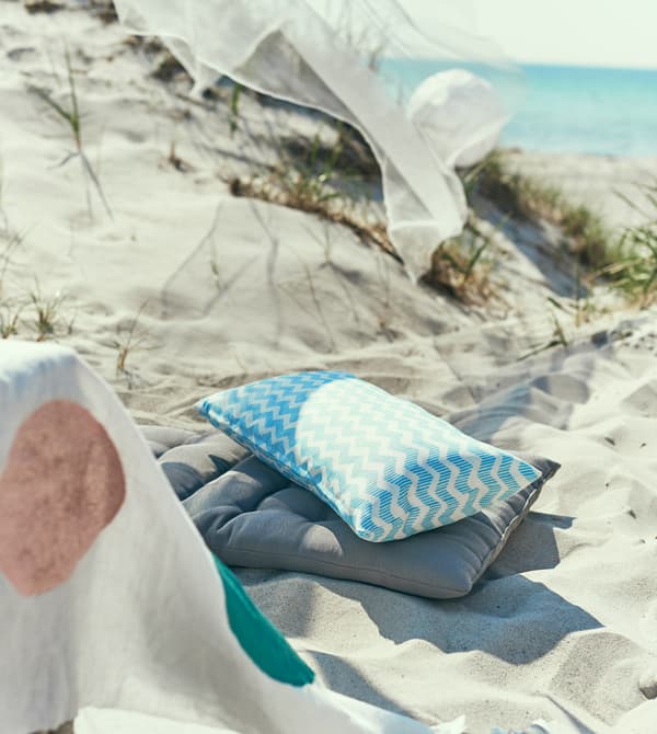 Two cushions sit in the sand.