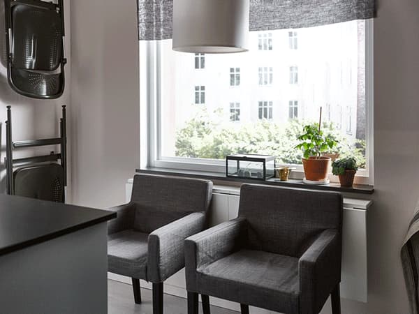 Two drop-leaf tables, prepared with breakfast, side-by-side with the leaves up and down, facing a window.