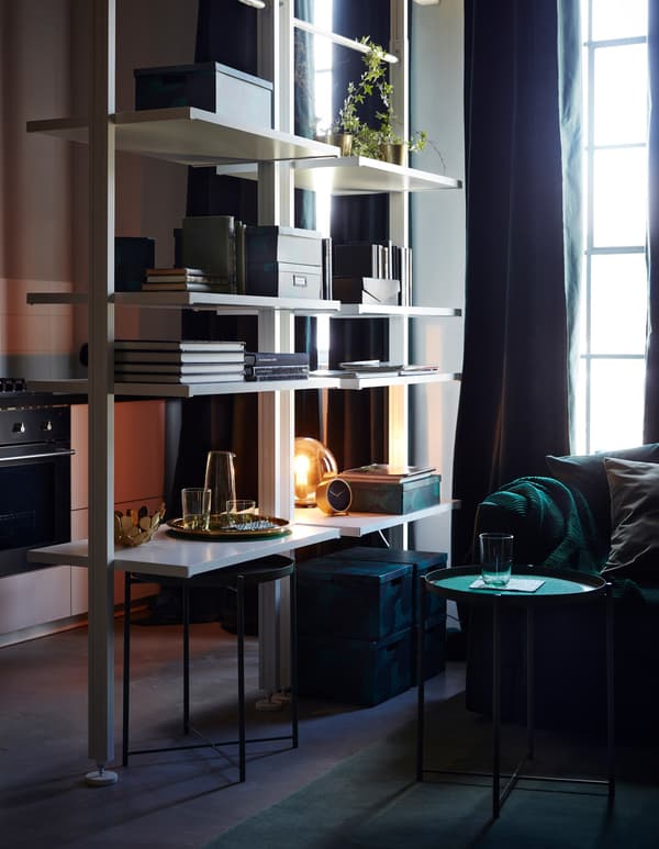 Two ELVARLI open shelving units divide the living room and kitchen in this home.