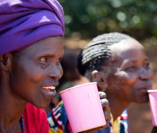 Two female workers from the White Nile coffee project in Uganda having coffee during a break.