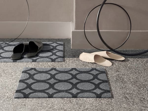 Two grey IKEA MEJLS door mats with a black circle pattern. They’re made from recycled PET bottles.