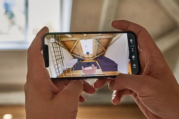 Two hand holding a mobile phone that shows IKEA Kreativ, a 3D visualisation tool.