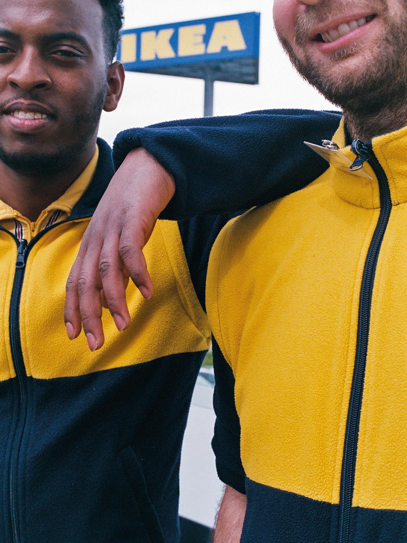 Two IKEA co-workers stand side by side, wearing company uniforms, representing IKEA for the World Refugee Day campaign.