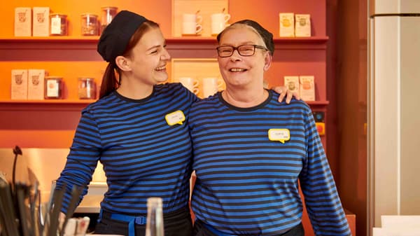 Two IKEA Food co-workers wearing a blue IKEA uniform