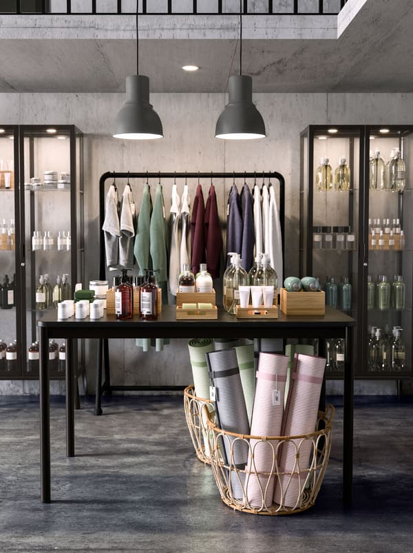 Two MILSBO glass door cabinets and TURBO clothes rack holding products for sale in the shop. SNIDAD basket is on the floor.