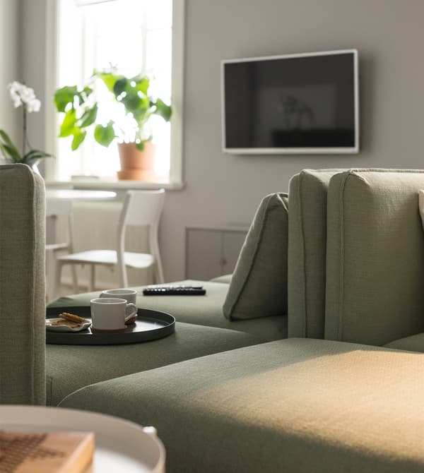 Two modular sofas sit back-to-back and a tv hangs on the wall.