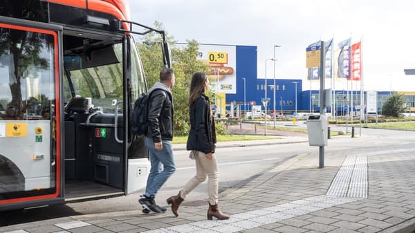 two people getting off the bus outfront of an IKEA