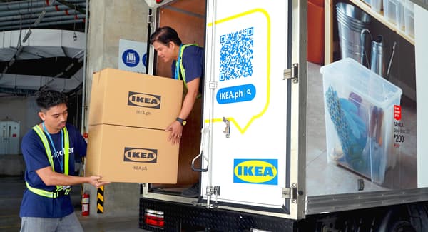 Two people loading IKEA boxes onto a truck.